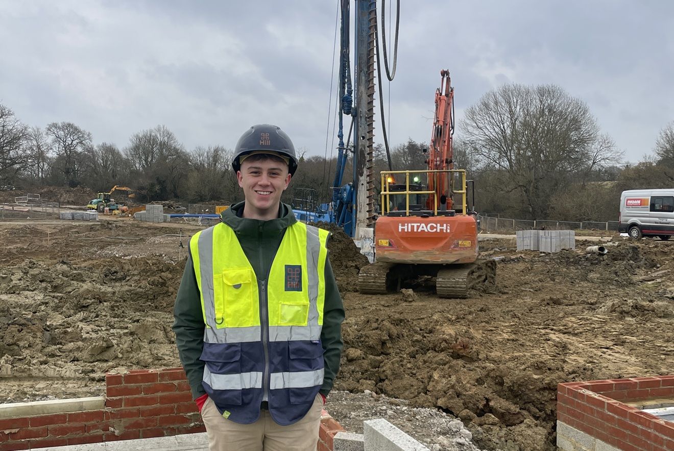 Young man on construction site with crane in background