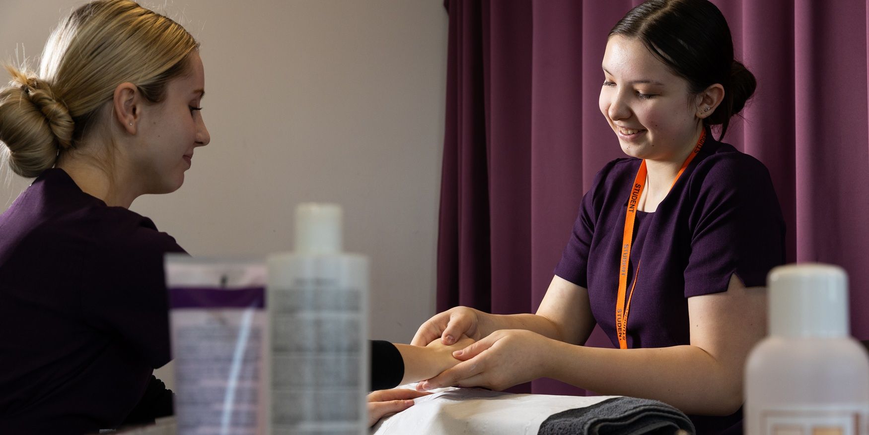 Student giving person beauty treatment