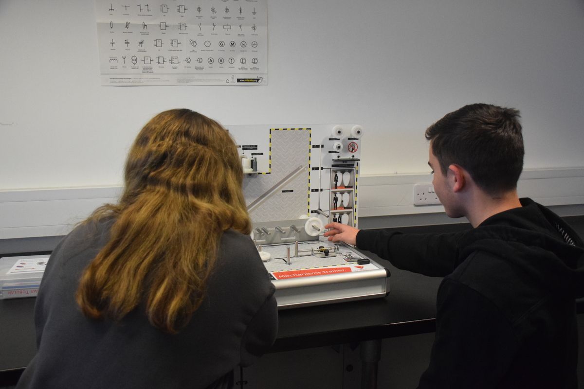 Two students looking at engineering model