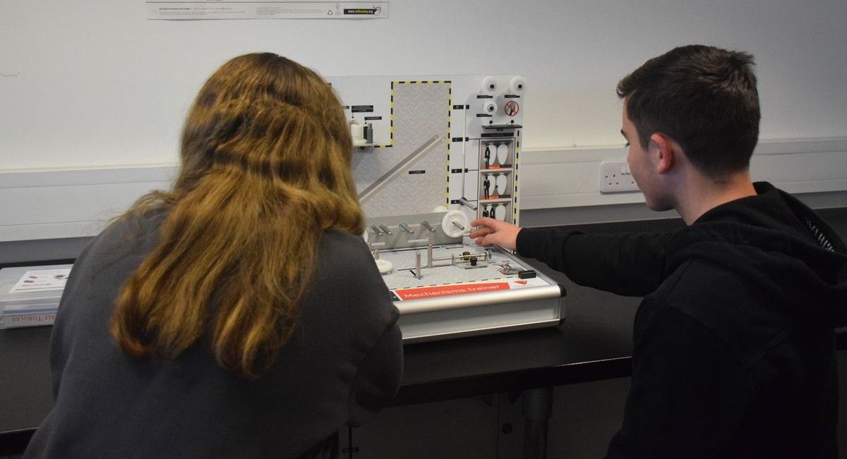 Two students looking at engineering model