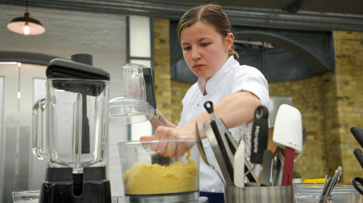 Young lady in kitchen in white chef's apron