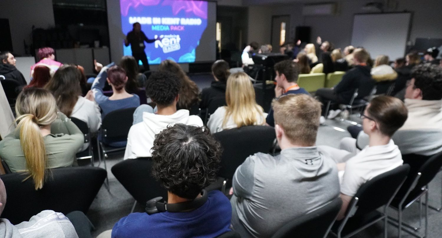 Man stood in room in front of a number of students